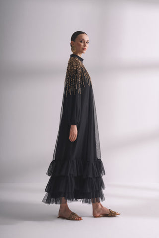 Платье с ниспадающим вырезом, украшенное камнями и плиссированными рукавами.